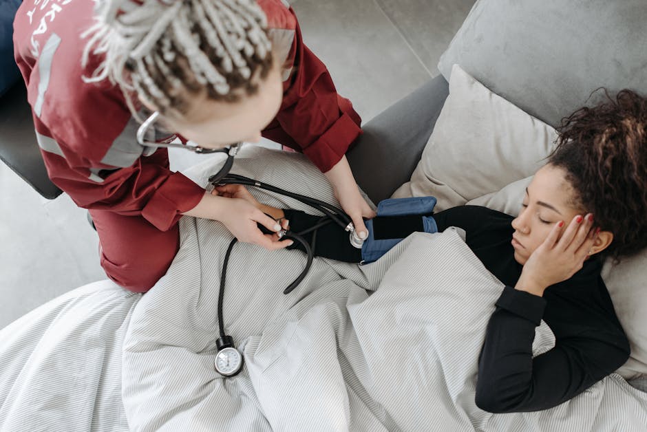 Paramedic measuring patient's blood pressure indoors, illustrating home healthcare assistance.